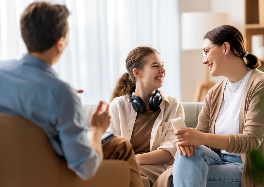 Mother and teenage daughter with headphones smiling in a health consultation.