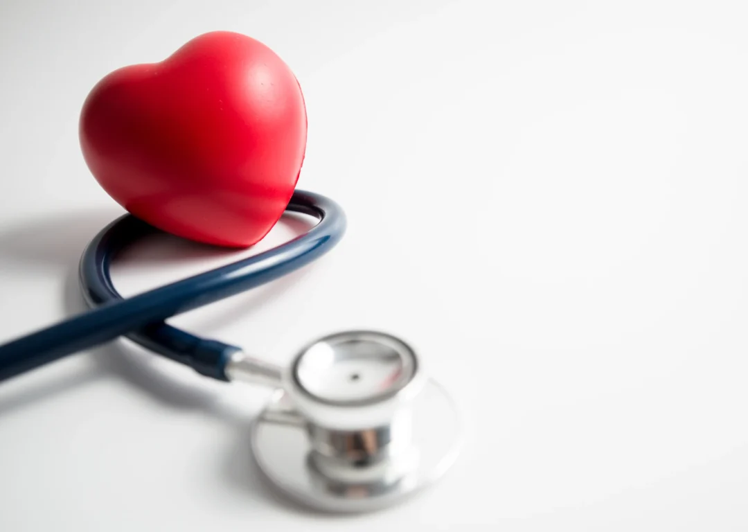 Red heart stress ball and stethoscope, symbolising heart health.